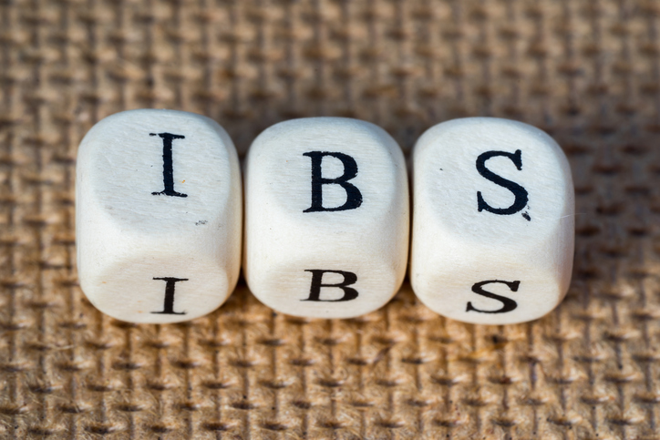 IBS - drei Würfel mit der Aufschrift I - B - S auf braunem Hintergrund