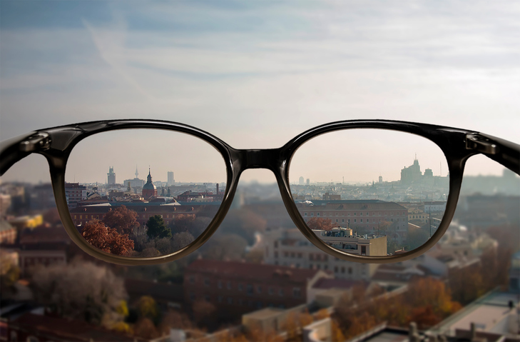 Myopie - verschwommene Sicht in die Ferne - verschwommener Stadthintergrund und Brille mit scharfer Sicht