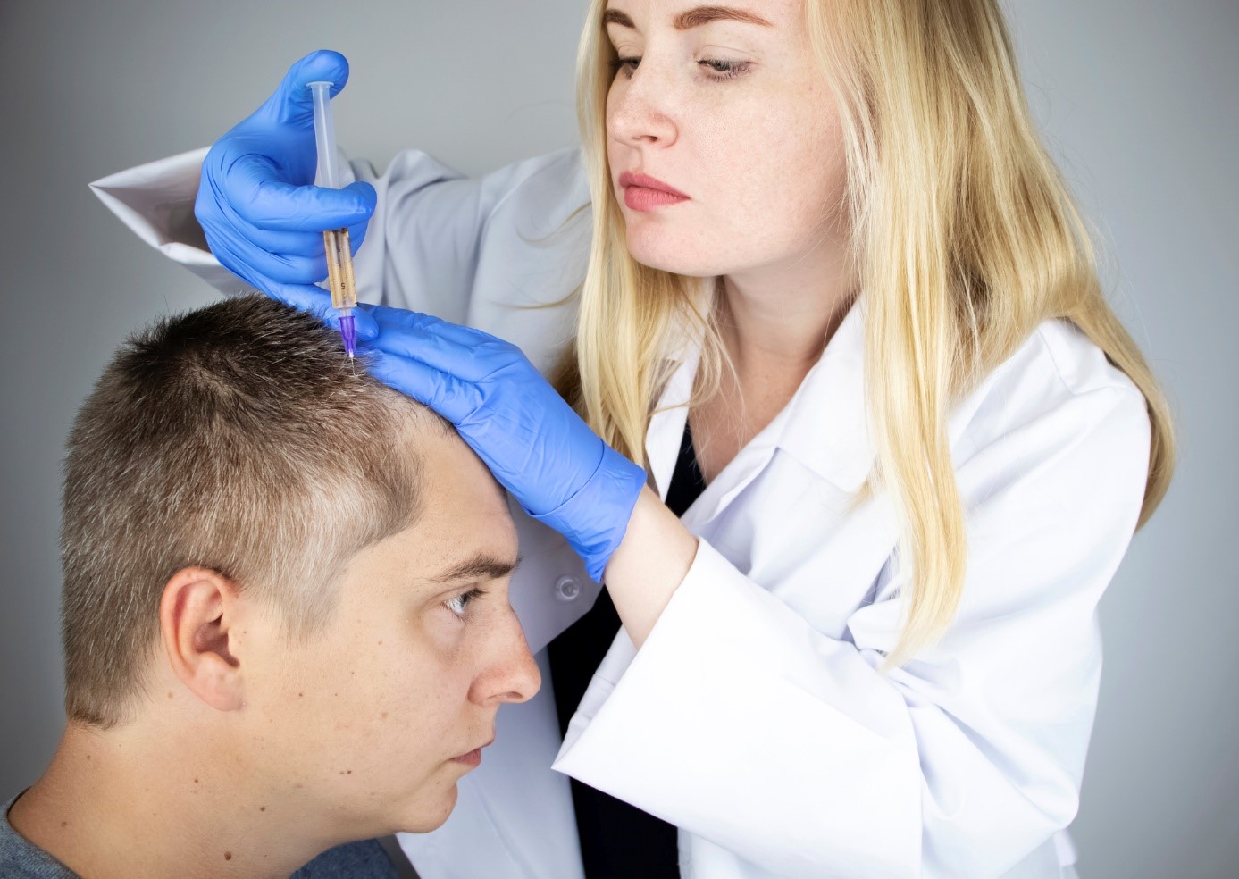 Behandlung von Haarausfall, ein Arzt injiziert ein Medikament in den Kopf eines Herrn, eines Patienten