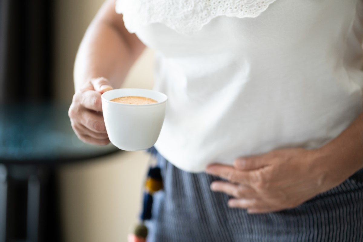 Eine Tasse Kaffee in der Hand als Risikofaktor für die Verschlimmerung von Refluxsymptomen