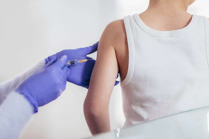 Impfung - ein Arzt, der einem Kind einen Impfstoff injiziert