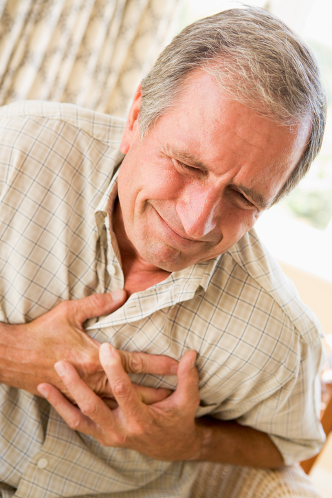 Ein älterer Mann hält seine Brust im Herzbereich, hat Herzklopfen, d.h. Herzunruhe und Angina, d.h. Brustschmerzen
