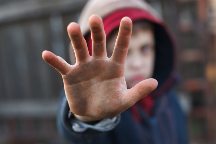Kind mit schmutzigen Händen, die Hand zeigt nach vorne
