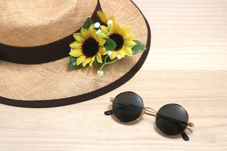 Hut mit Sonnenblumen und Brille
