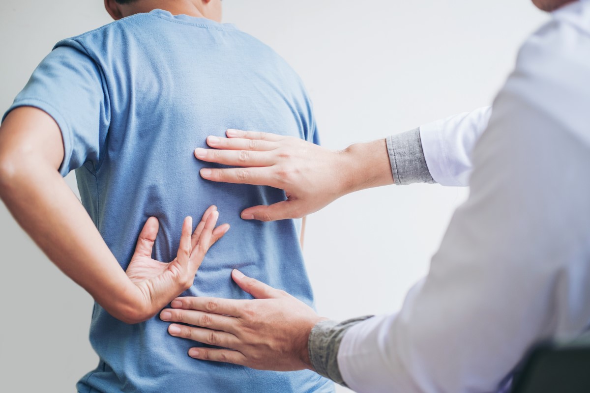 Arzt und Patient sprechen über Rückenschmerzen