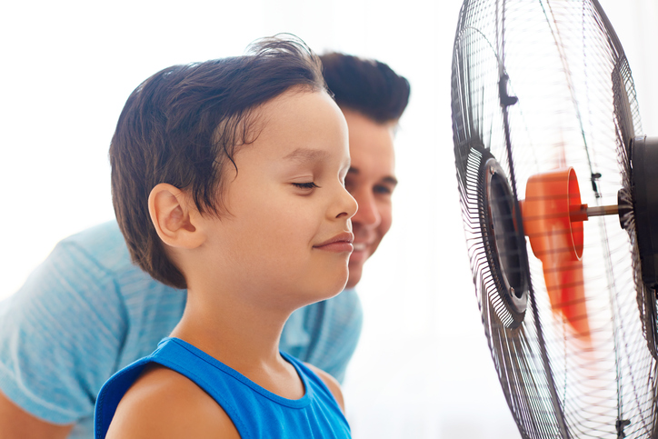 Ein Junge und sein Vater stehen vor einem Ventilator