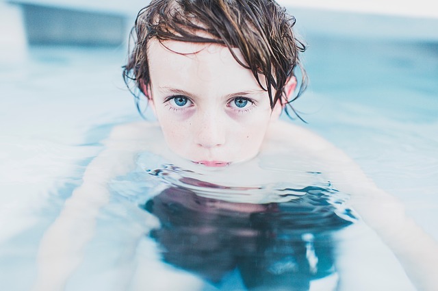 der Junge ist im Schwimmbad, Schwimmen ist eine geeignete körperliche Aktivität