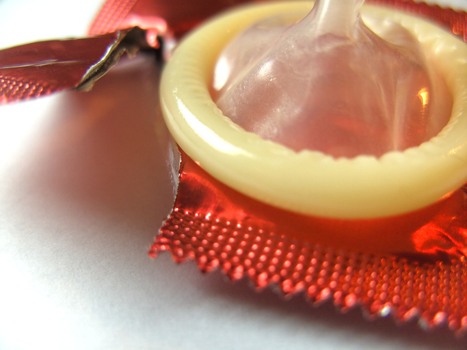 Aus der Verpackung entferntes Kondom, gerissene Verpackung, zur Vorbeugung von Gonorrhoe und anderen Geschlechtskrankheiten, Barriere-Verhütung