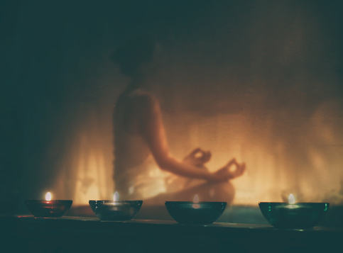 Frau meditiert bei Kerzenlicht