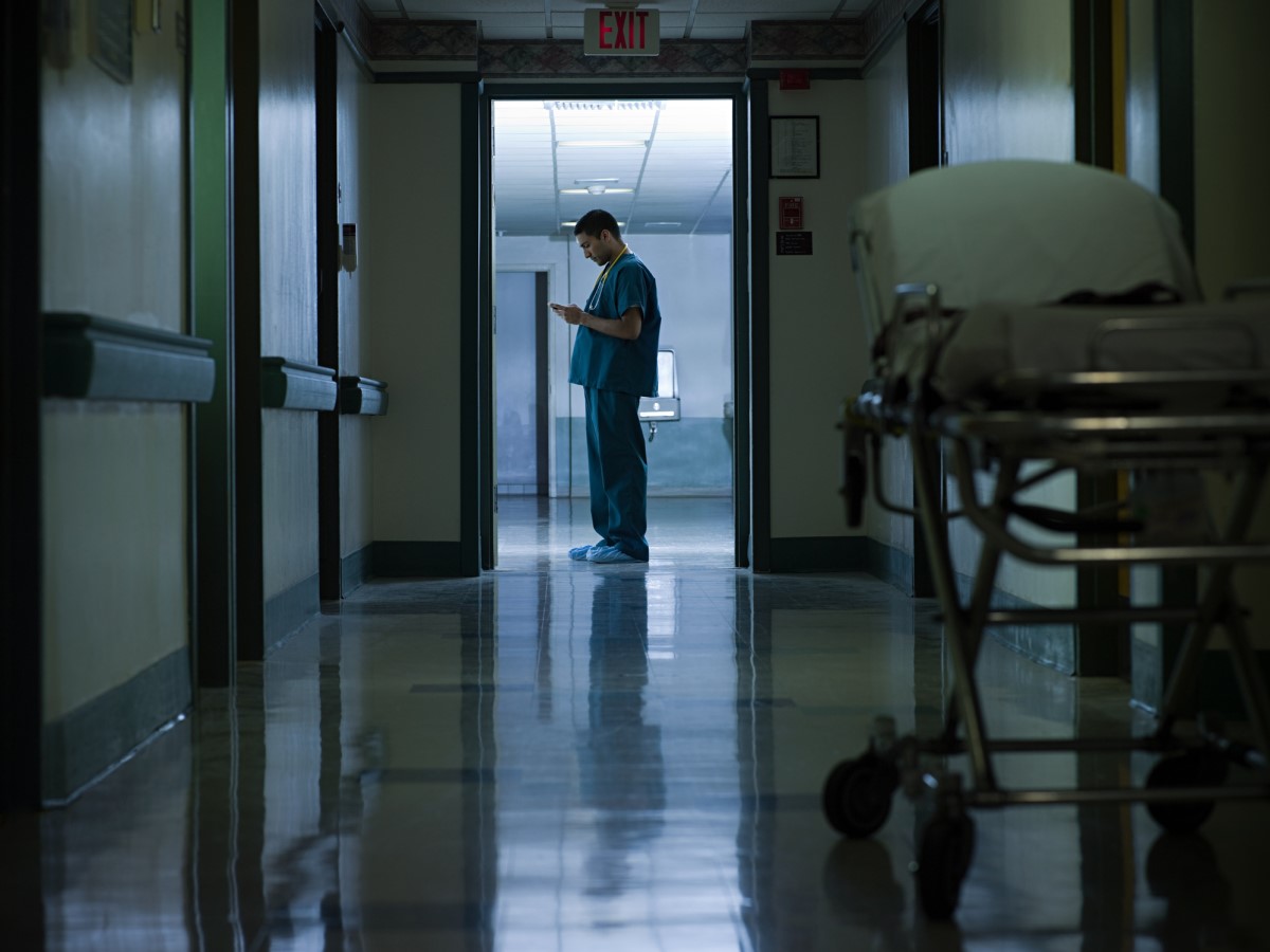 Nachtarbeit und ihre Auswirkungen auf Störungen des zirkadianen Rhythmus - Ein Beispiel ist die Nachtarbeit von Beschäftigten im Gesundheitswesen - ein Arzt, der auf dem Flur eines Krankenhauses steht.