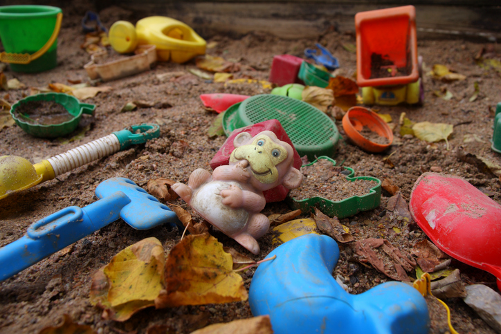 Altes Spielzeug in einem verschmutzten Sandkasten