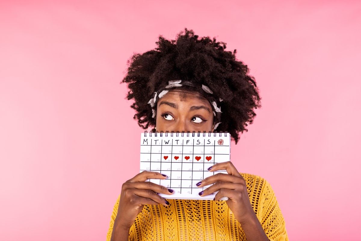 Frau hält einen Menstruationskalender