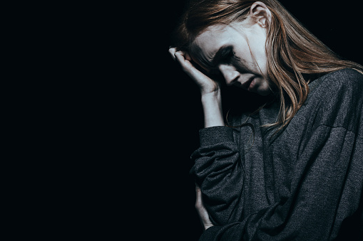 depressive Frau, die weint und sich den Kopf hält