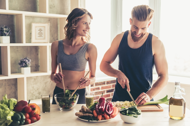 Ein Mann und eine Frau bereiten in der Küche eine gesunde Mahlzeit zu.