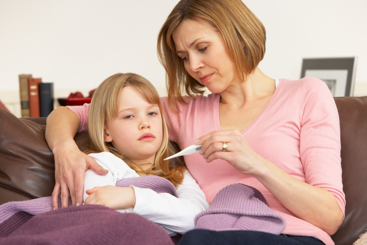 Besorgte Mutter misst die Temperatur ihrer Tochter