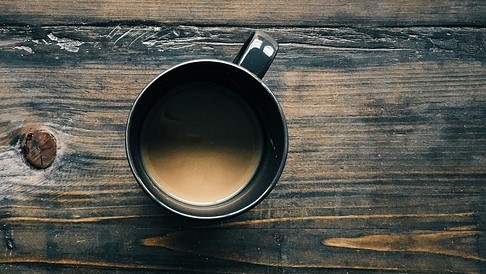 Kaffee in einer Tasse auf dem Tisch, Ansicht von oben