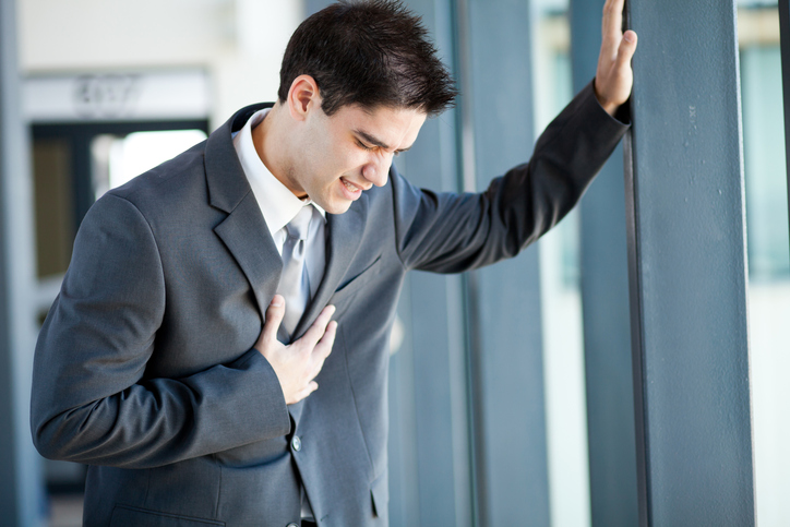 Ein junger Mann, ein Geschäftsmann, hat Probleme, Schmerzen in der Brust, vielleicht hat er einen Herzinfarkt oder ist überarbeitet