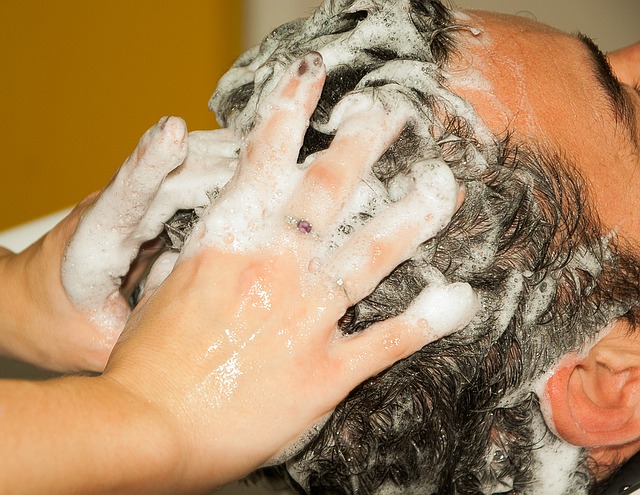 Männer waschen sich die Haare und lassen sich den Kopf schamponieren, Hände im Haar