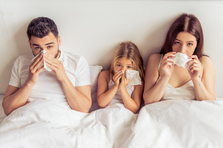 Die Familie, d.h. Vater, Mutter und Tochter liegen im Bett, die Nasen sind voll, sie sind erkältet, wegen einer Krankheit, z.B. einer Grippe