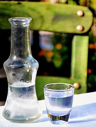 Flasche und Glas hochprozentigen Alkohols, hausgemachter Schnaps