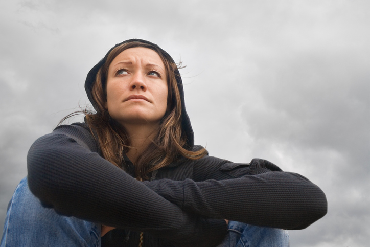 Frau sitzend, depressive Stimmung, bewölktes Wetter