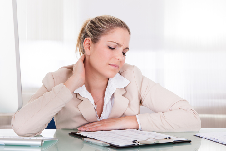 Eine Frau hat steife Muskeln der Halswirbelsäule, des Nackens, für langes Sitzen, sitzende Arbeit und für Arbeitsstress